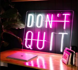 Déco murale originale rose "Don't quit" sur un bureau