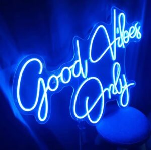 Décoration murale lumineuse "Good vibes only" bleu sur une chaise